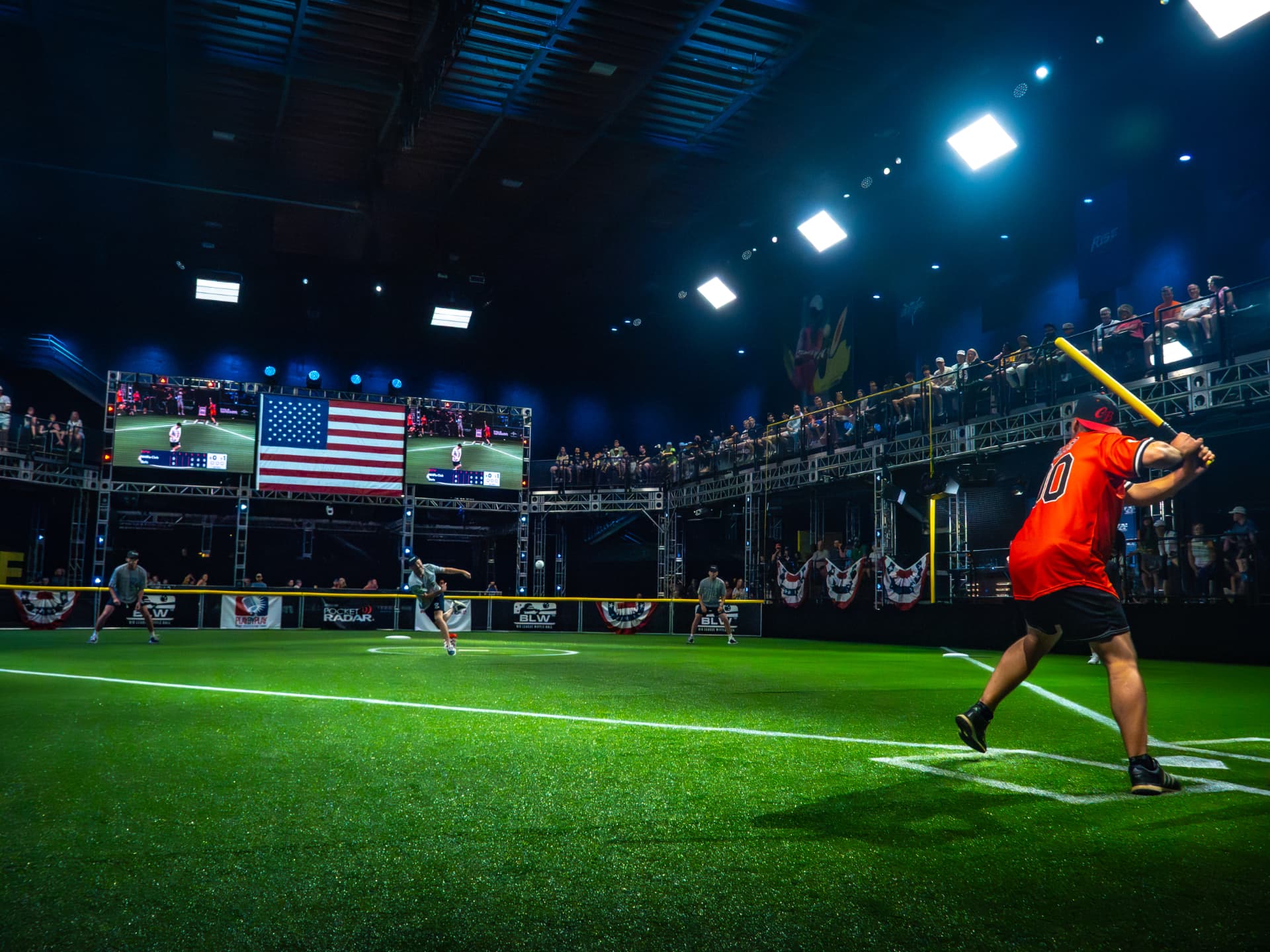 A Big League Wiffle Ball® batter at the plate in a packed indoor arena